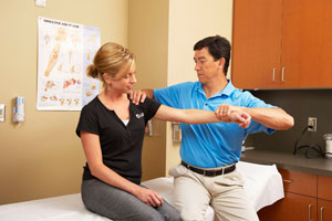 Dr. Matthew Hwang tests shoulder movement on patient at the Knee and Shoulder Center at St. Cloud Orthopedics.